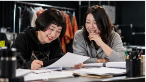 コントの台本を確認する女性コンビをイメージした画像